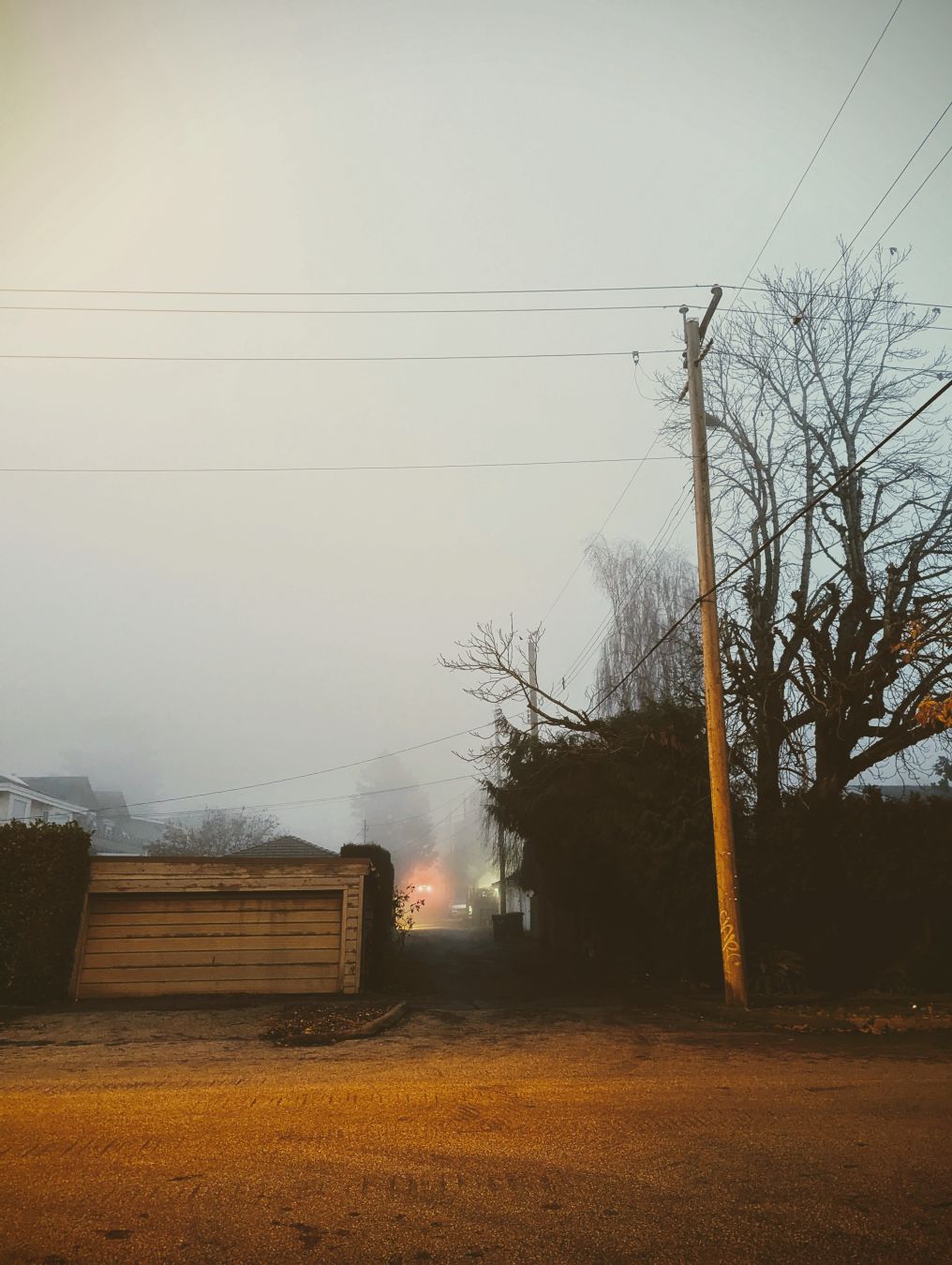 An alley way and an old garage on a foggy evening in the city